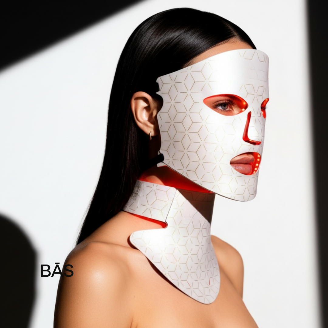 Person wearing a white LED face and neck mask with red accents on a white background