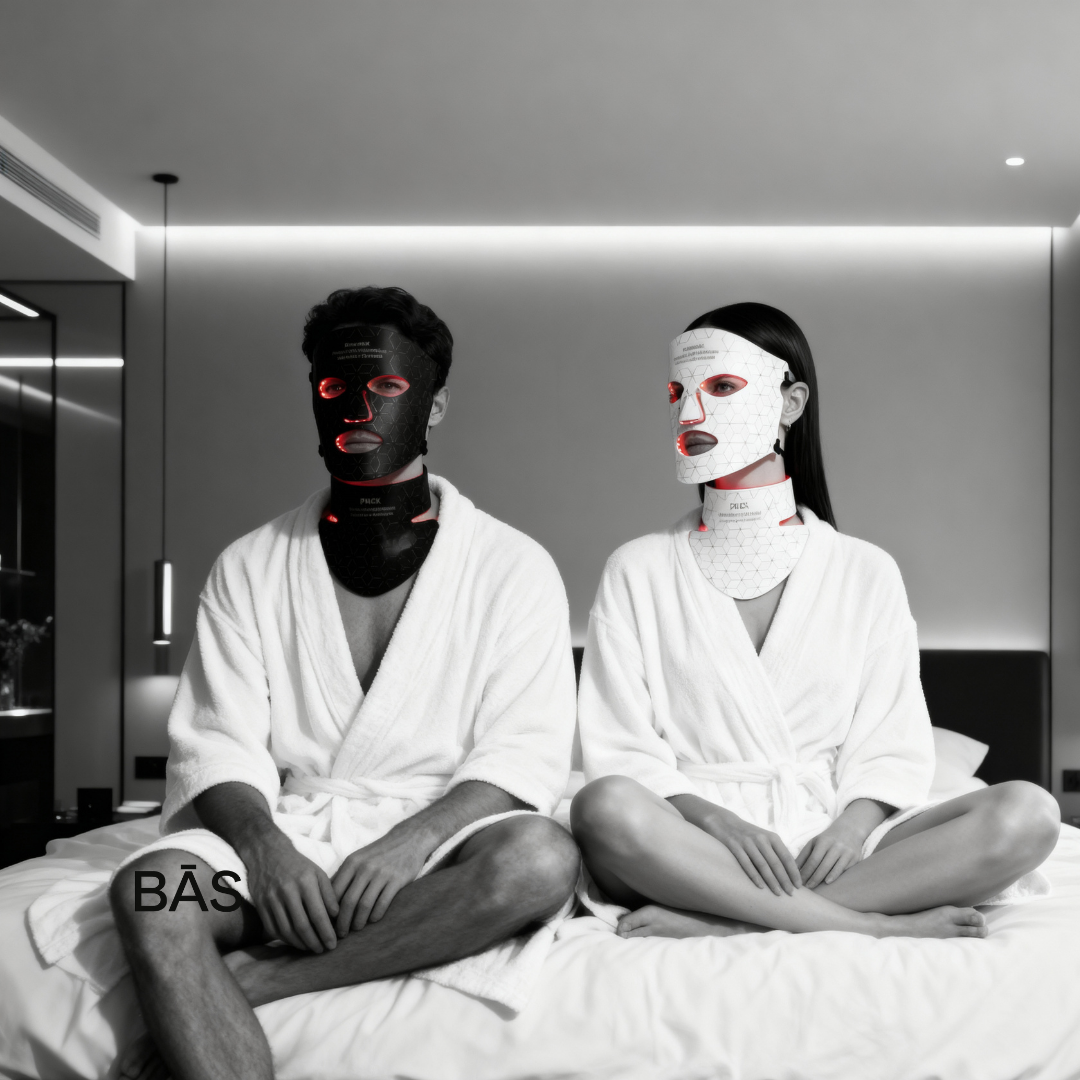 Two people wearing face masks and white robes in a modern room. his and hers LED light therapy.