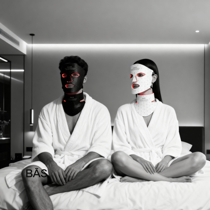 Two people wearing face masks and white robes in a modern room. his and hers LED light therapy.